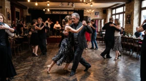 Un couple danse le tango en embrace rapproché au milieu d'une piste de milonga, en pleine marche partagée avec d'autres couples.